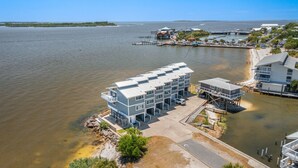 A waterfront hotel with a modern design, featuring multiple balconies and a dock.