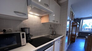 A modern kitchen with a microwave, coffee maker, and sink. - OURS BLANC 9 – Studio with a beautiful mountain view, close to the aquatic area. (La Clusaz)