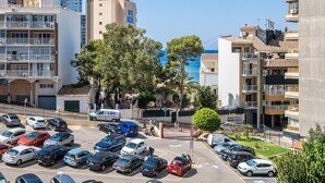 Un hôtel à étages, doté de balcons et d’un parking rempli de voitures.