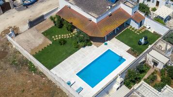 Luftaufnahme eines Wohnhauses mit Schwimmbad, Garten und Bootsanleger.