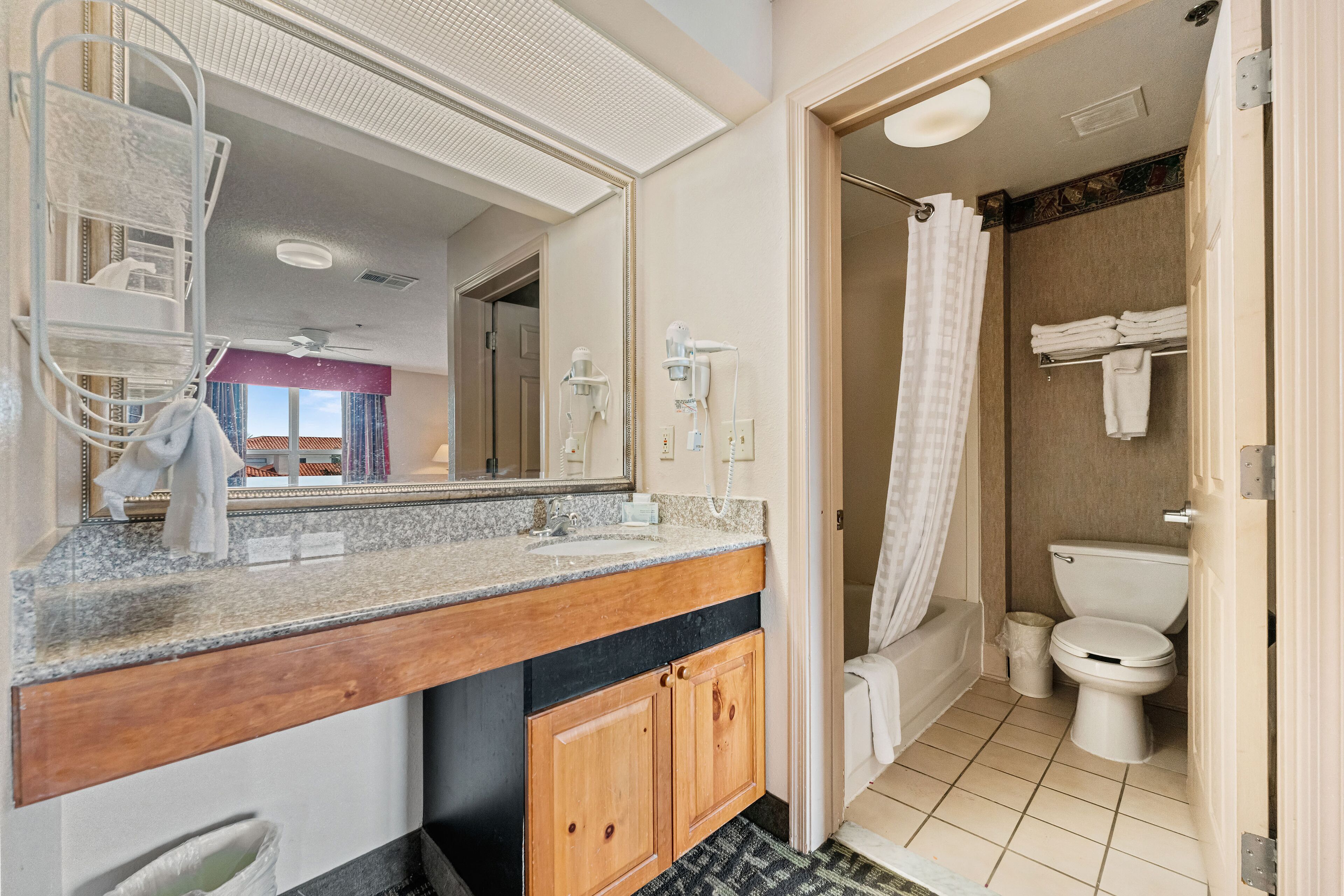 Un bagno con lavabo, specchio, servizi igienici e mobile.