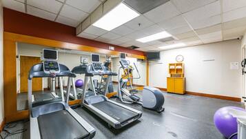 Ein Fitnessstudio mit Laufbändern, Crosstrainern und Übungsbällen.