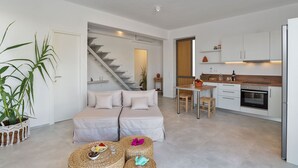 A modern apartment with a living area, kitchen, and staircase. - Villa Annassa Almyrida (CHANIA)