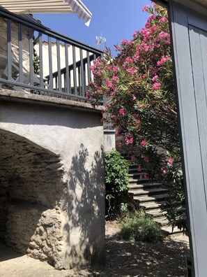 Una escalera de piedra que sube a un balcón con barandilla de metal.
