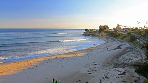 A beach with a clear view of the ocean, a sandy shore, and a few people walking. - Little Palm Cottage - Steps from Shoreline Park, walk to beach, live like a local (Santa Barbara)