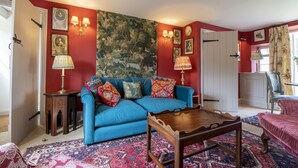 A living room with a blue sofa, patterned rug, and wooden coffee table. - Beau Repaire -  Castle Howard, Coneysthorpe , Yorkshire (York)