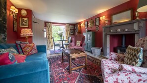 A cozy living room with a blue sofa, a patterned rug, and a fireplace. - Beau Repaire -  Castle Howard, Coneysthorpe , Yorkshire (York)