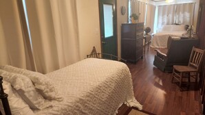 Une chambre à coucher comprenant un lit, une commode, une chaise et un bureau.