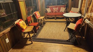 Une pièce chaleureuse avec des murs en bois, un banc en bois, une table ronde et deux chaises.
