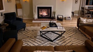 Una sala de estar con chimenea, televisión y una mesa de centro.