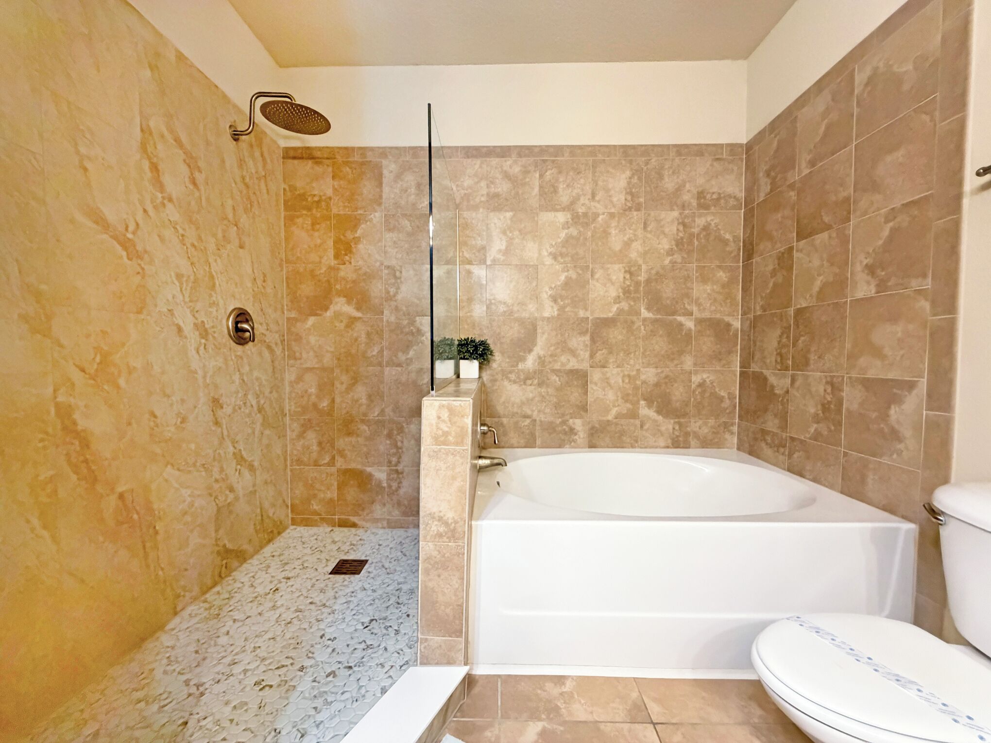 Un baño con ducha, bañera y retrete.