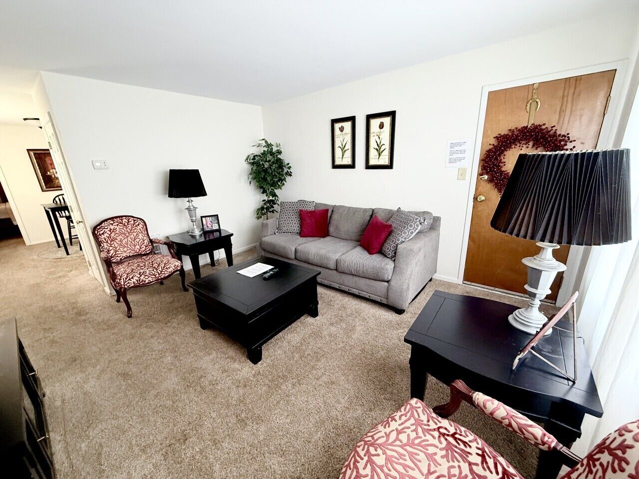 A living room with a sofa, two armchairs, a coffee table, and a side table.