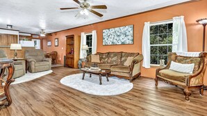 A living room with a wooden floor, a ceiling fan, a coffee table, and two sofas. - Private, cozy home - Handicapped Accessible no by- with great views  (Fletcher)
