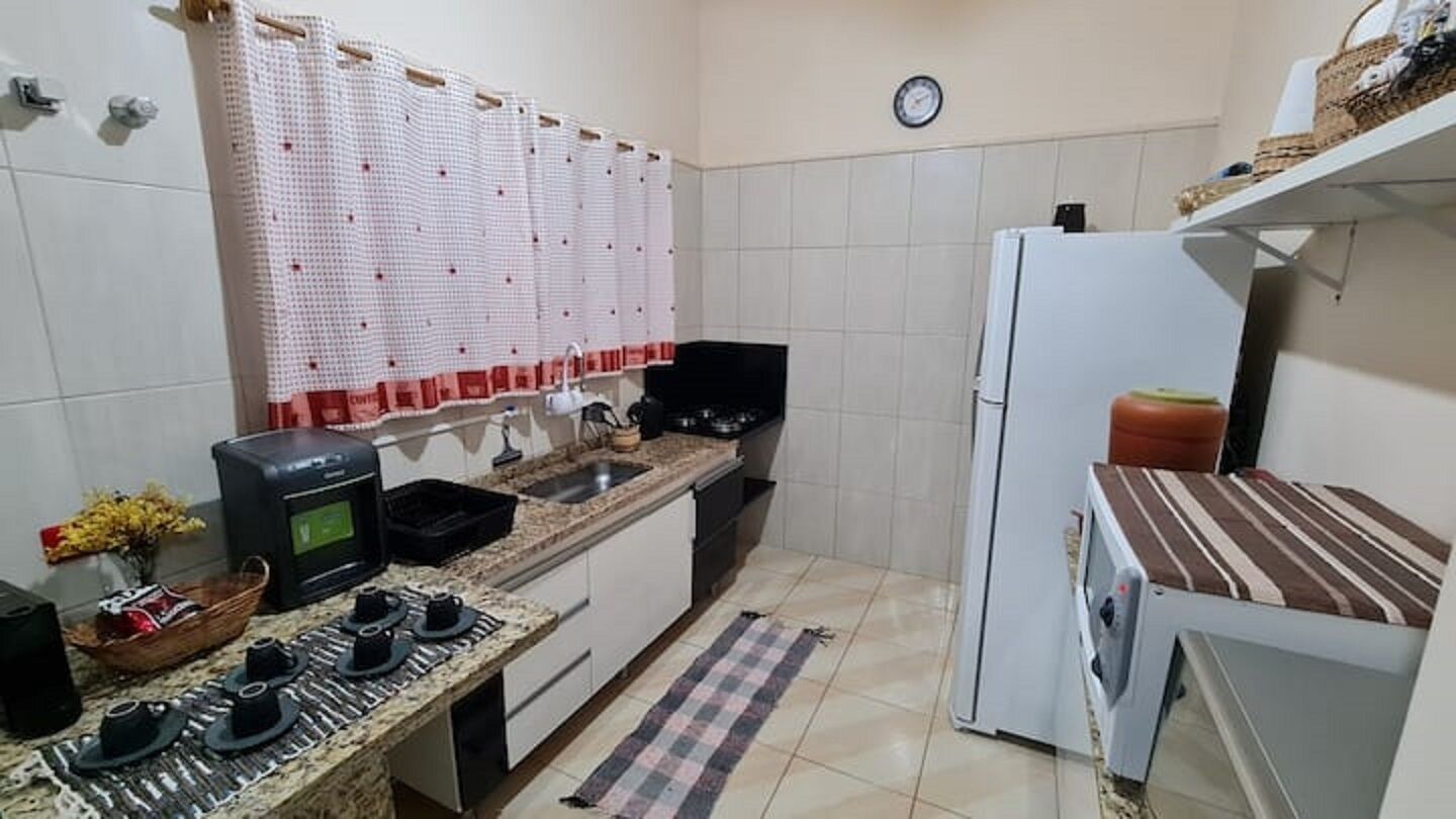A compact kitchen with a microwave, stove, sink, and a refrigerator.