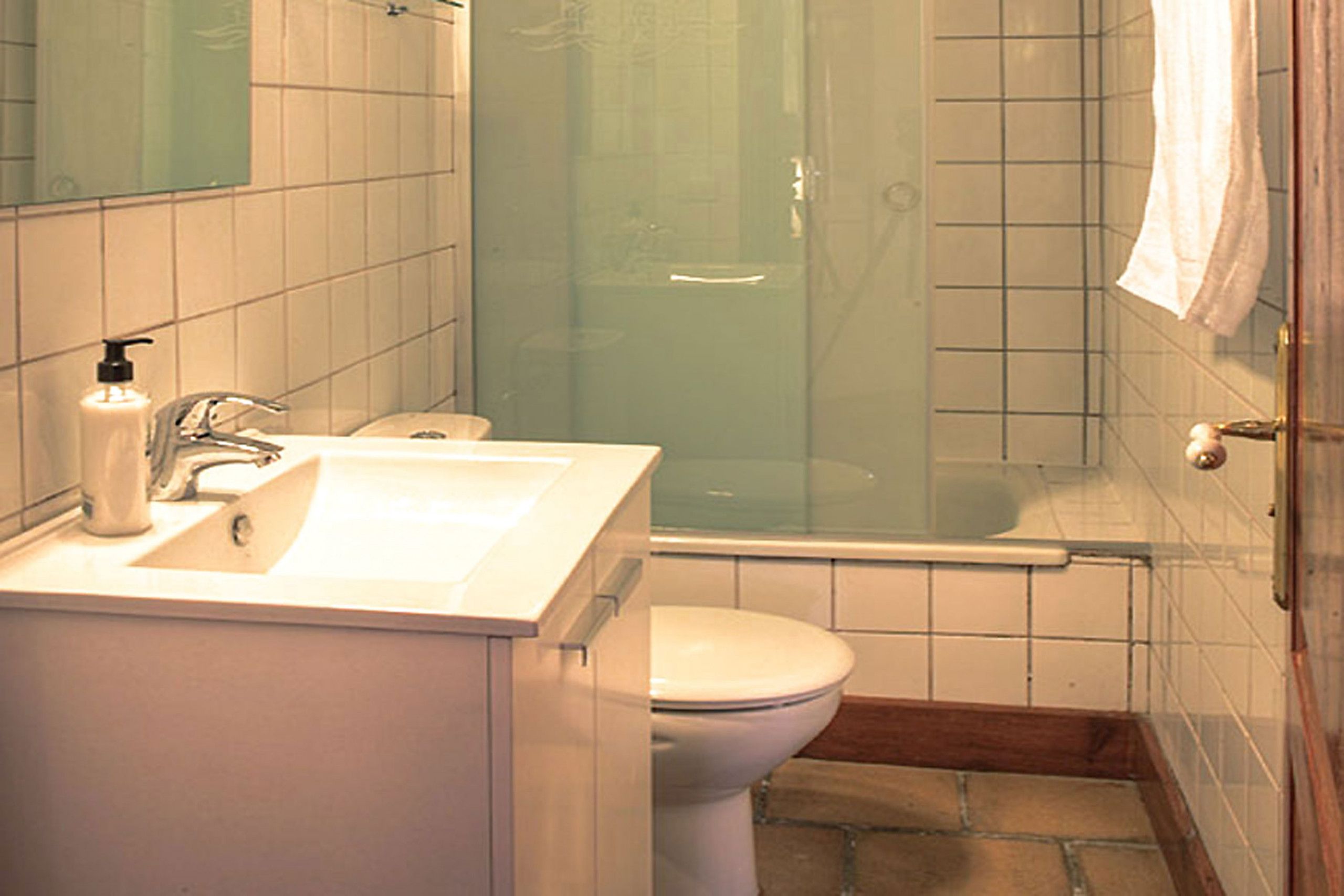 A bathroom with a sink, toilet, and glass-enclosed shower.