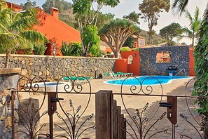 A pool area with a stone wall, lounge chairs, and a stone staircase. - Finca Los Viñedos (Tacoronte)