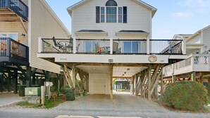 A two-story building with a balcony, a garage entrance, and a number '915' sign. - Cozy Beach House w/ Ocean Views & GREAT Amenities! (Myrtle Beach)