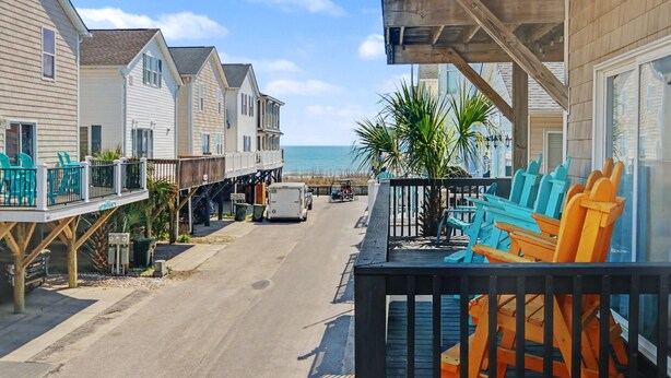 A coastal street with houses, a truck, and a view of the ocean. - Cozy Beach House w/ Ocean Views & GREAT Amenities! (Myrtle Beach)