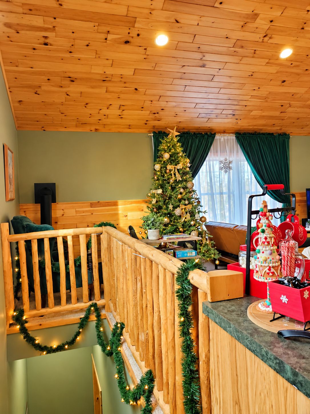 Un interior de madera con un árbol de Navidad, una escalera y un mostrador decorado para las festividades.