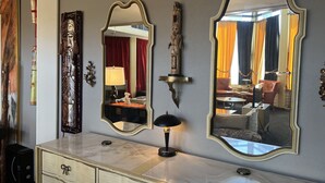 Una habitació amb un aparador de marbre, tres miralls fixats a la paret i una peça decorativa a la pared.