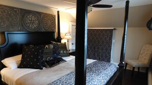 A four-poster bed with a dark headboard, a patterned bedspread, and decorative pillows. - Yellowstone Village Resort  
2 Houses  
same day bookings
Deer,Fire Pits,Swings (Cody)