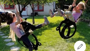 Two children on a swing set in a grassy outdoor area. - Yellowstone Village Resort  
2 Houses  
same day bookings
Deer,Fire Pits,Swings (Cody)
