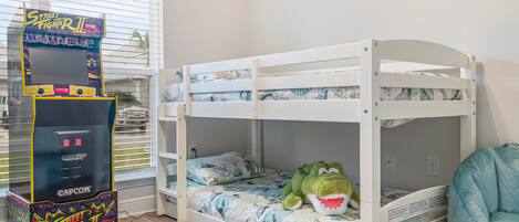 Een stapelbed met een pluche knuffel en een spelconsole.