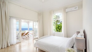 Une chambre à coucher avec un lit, une lampe et une vue sur la mer.