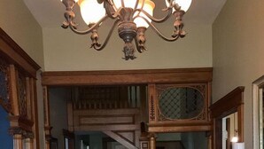 A grand foyer with a wooden staircase, a chandelier, and a rug. - Historic home in quaint town of South Pittsburg. Just off I-24. (South Pittsburg)