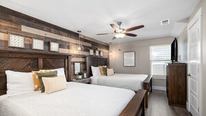 A bedroom with two beds, a ceiling fan, a wooden headboard, and a window with blinds. - Indoor/Outdoor Pool,Hot Tub, Firepit,Game Room, Pickleball, Pool Table,Lakeview (Branson)