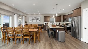 A modern kitchen with wooden chairs, a stainless steel refrigerator, and a large island. - Indoor/Outdoor Pool,Hot Tub, Firepit,Game Room, Pickleball, Pool Table,Lakeview (Branson)