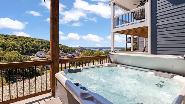 A hot tub on a wooden deck with a view of a coastal landscape. - Indoor/Outdoor Pool,Hot Tub, Firepit,Game Room, Pickleball, Pool Table,Lakeview (Branson)