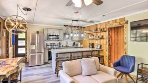 A modern kitchen with a central island, stainless steel appliances, and wooden accents. - Remodeled Cabin w/ Fire Pit on Norfork Lake! (Elizabeth)