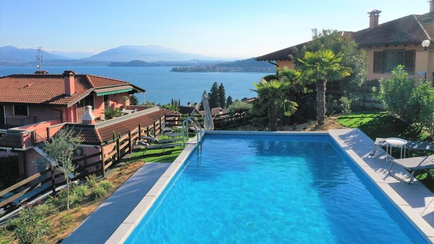 A swimming pool with a view of a lake and mountains. - Penthouse Andrea apartment with private pool (Meina)