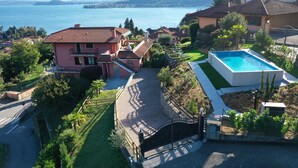 A residential property with a swimming pool, a tennis court, and a view of a lake. - Penthouse Andrea apartment with private pool (Meina)