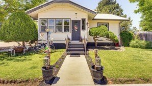 A single-story house with a front porch, a small garden, and a bicycle parked outside.