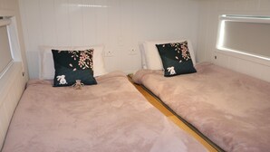 A bedroom with two beds, each with a pink blanket and a floral pillow. - The Pink Lake Tiny House - 'sakura' (Lochiel)