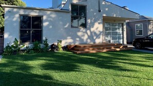 Una casa moderna con un garaje amplio, un porche cubierto y un césped cuidado.