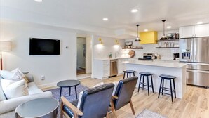 Un appartement moderne comprenant un salon, une cuisine et un coin repas.
