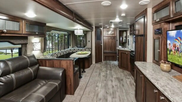 A modern RV interior with a kitchen, dining area, and living space. - ⛱ Heartland North Trail 31' RV (Manchaca)