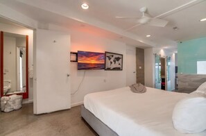 A bedroom with a bed, a ceiling fan, and two wall-mounted artworks. - 2 Modern Units in Heart of Little Italy! (San Diego)