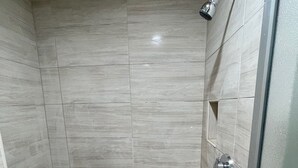 A shower with a tiled floor and a showerhead. - Hilltop Motor Inn (Los Angeles)