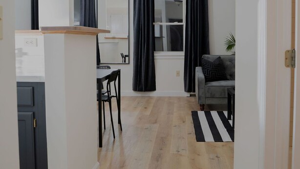 Una cocina moderna con comedor, sofá y alfombra a rayas.
