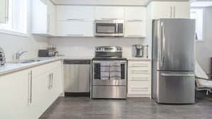 A modern kitchen with white cabinets, a stainless steel refrigerator, a microwave, a toaster, and an oven. - A Modern and Executive Unit~1 Parking Spot&Great Location - Close To Everything (London)