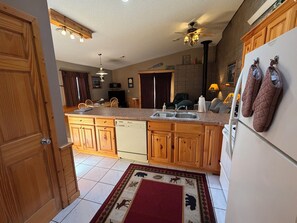 A kitchen with wooden cabinets, a dishwasher, a sink, and a refrigerator.