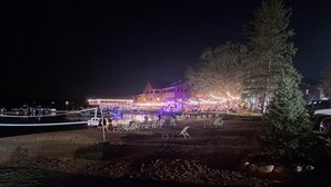 A waterfront property with a large building, outdoor seating, and a dock. - Winter, Spring, Summer or Fall, this place has it all! In Breezy Point Resort (Breezy Point)