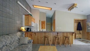 A compact living space with a kitchenette, a sofa, a coffee table, and a bar area with stools. - Winter, Spring, Summer or Fall, this place has it all! In Breezy Point Resort (Breezy Point)