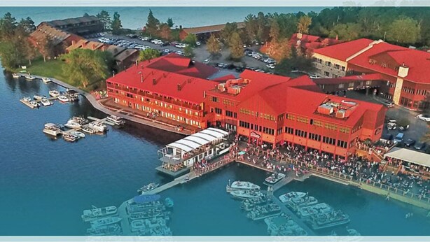 A large red building with multiple levels, a dock with boats, and a crowd of people. - Winter, Spring, Summer or Fall, this place has it all! In Breezy Point Resort (Breezy Point)