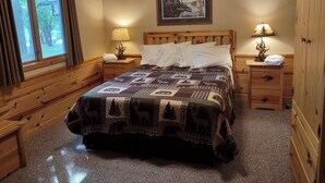 A cozy room with a wooden bed, two bedside tables with lamps, a large window with curtains, a painting on the wall, and a wooden wardrobe. - Winter, Spring, Summer or Fall, this place has it all! In Breezy Point Resort (Breezy Point)