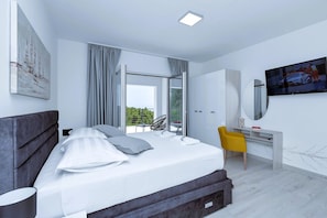 A modern bedroom with a bed, a desk, a chair, and a TV. - Villa Vivace with pool (Makarska)